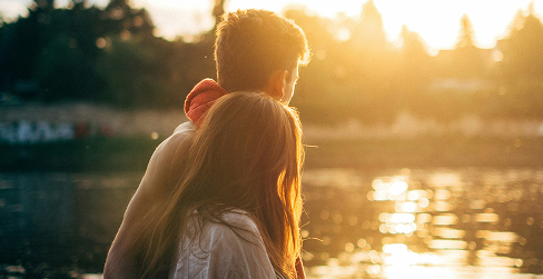 Pareja abrazándose al atardecer - Tranquilidad y protección familiar